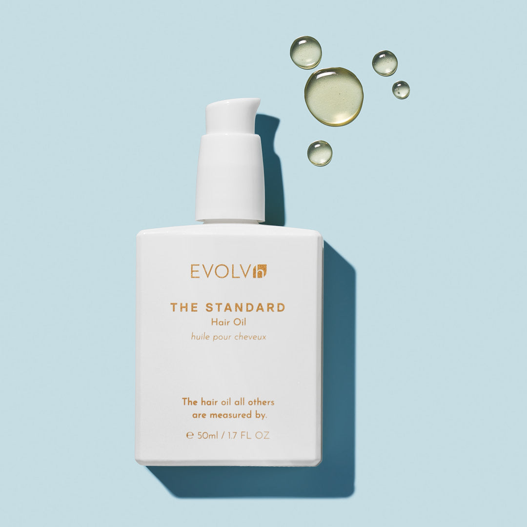 EVOLVh The Standard Hair Oil bottle with oil droplets